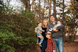 Family of five standing happily together in Roswell Park