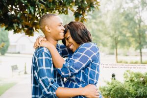 Behind the scenes glimps of an African American couple hugging and laughing in the middle of their engagement session with Pear Tree Photography Atlanta