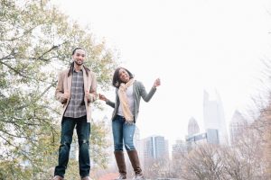 Engaged black couple dancing in the Atlanta skyline at Piedmont Park