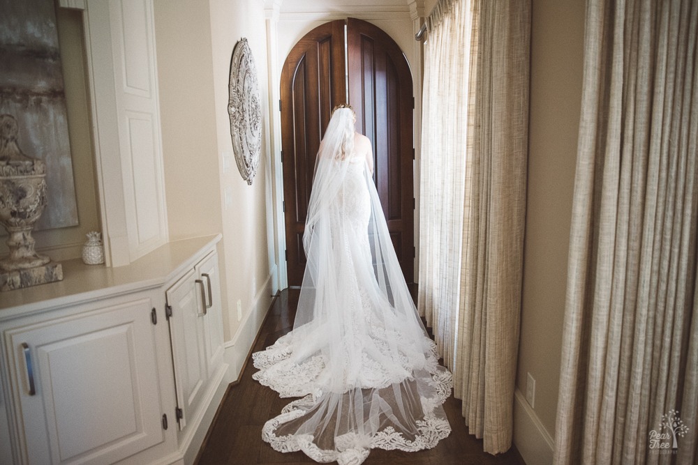 Bride walking out of private bedroom for reveal with bridesmaids