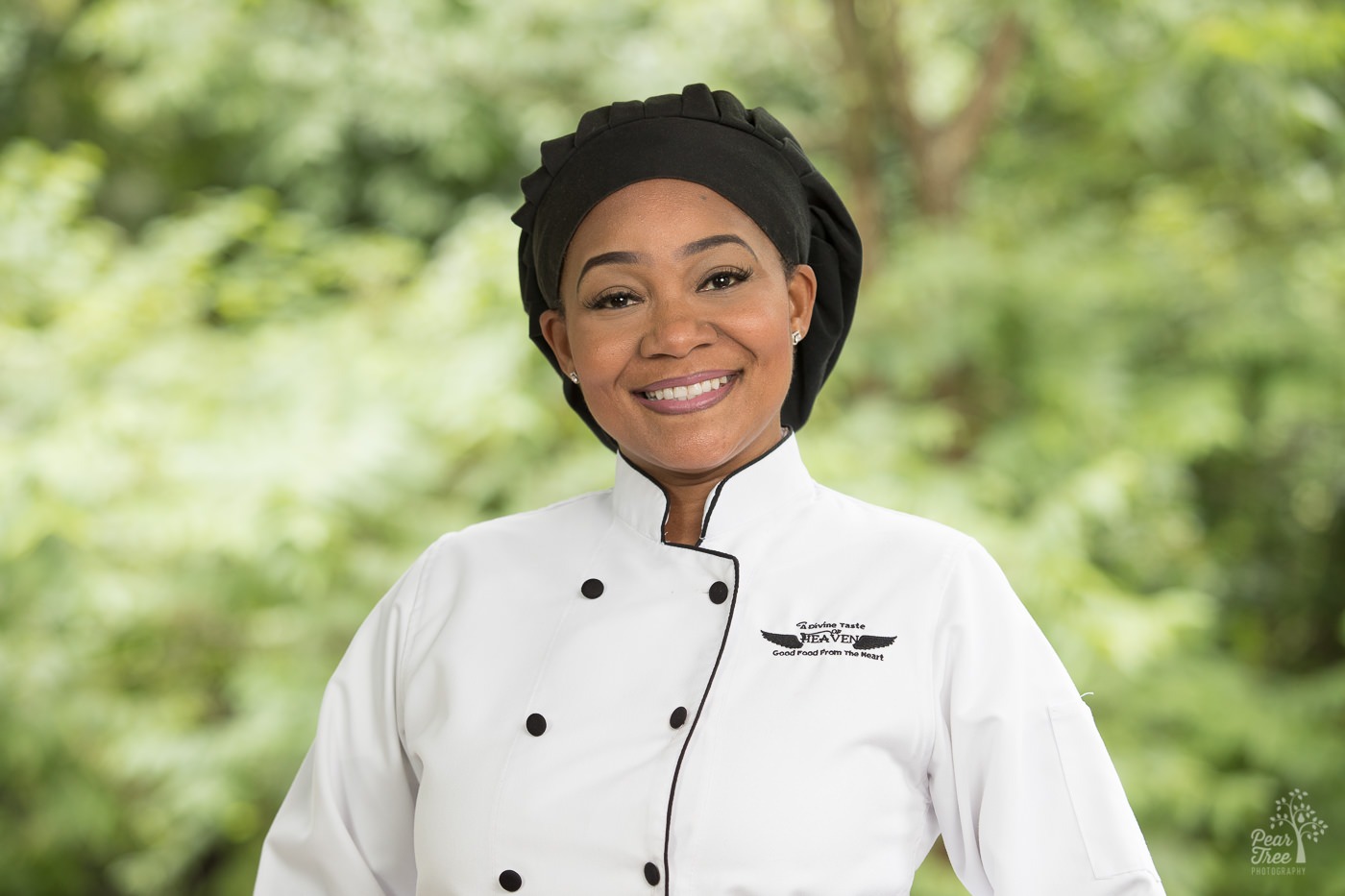 Headshot of chef Shantel Dean in white chef coat and black chef hat with Divine Taste of Heaven