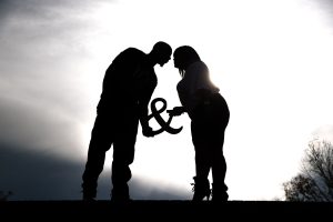 Engaged couple almost kissing while seen in silhouette