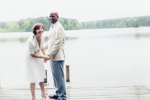 Happy married couple standing and laughing on Lake Acworth dock