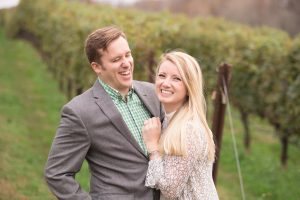 Happy engaged couple smiling and laughing in middle of north Georgia vineyard