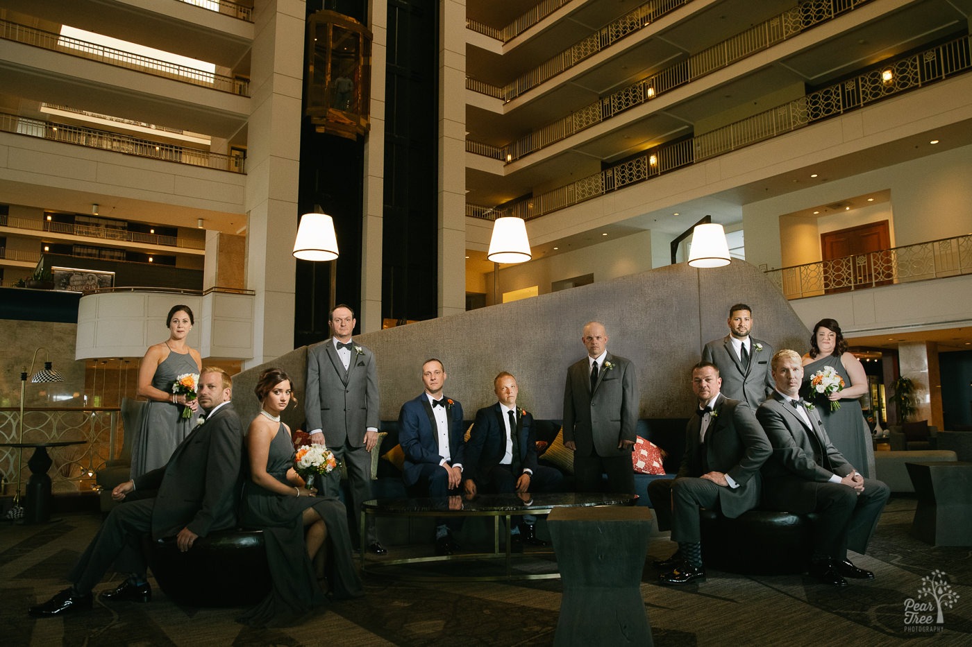 Two grooms with their serious wedding party inside the Renaissance Concourse Atlanta Airport Hotel lobby.