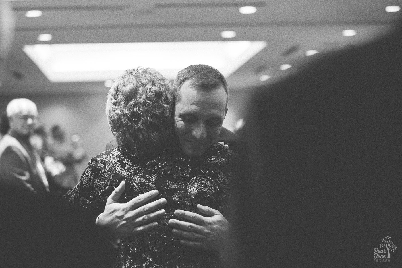 Groom hugging his mom after she walked him down the aisle for his marriage ceremony.