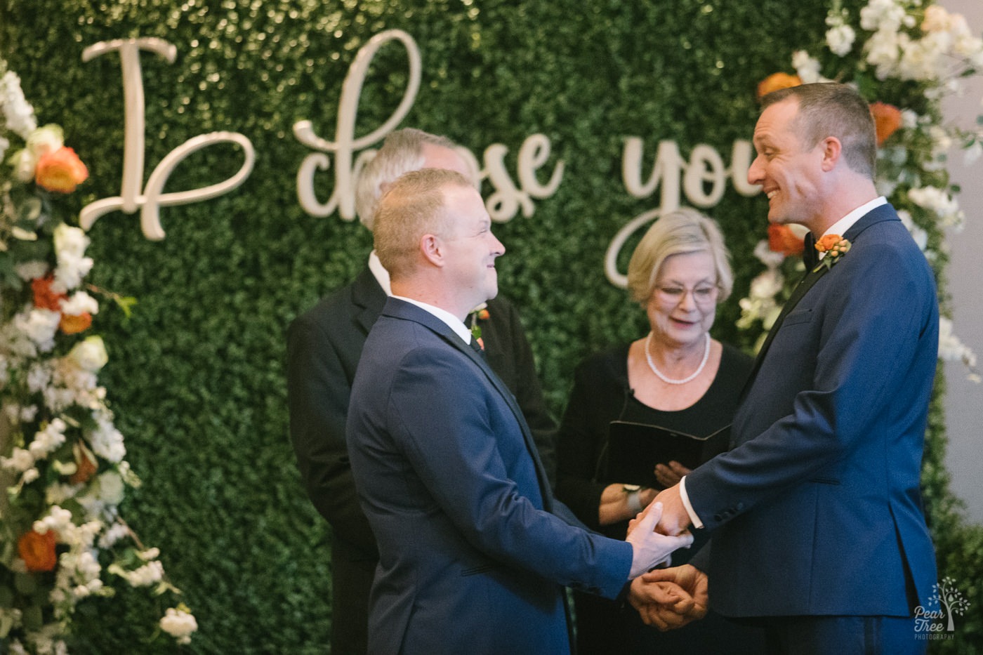 Grooms smiling in excitement as they're told they are officially married and can kiss each other.