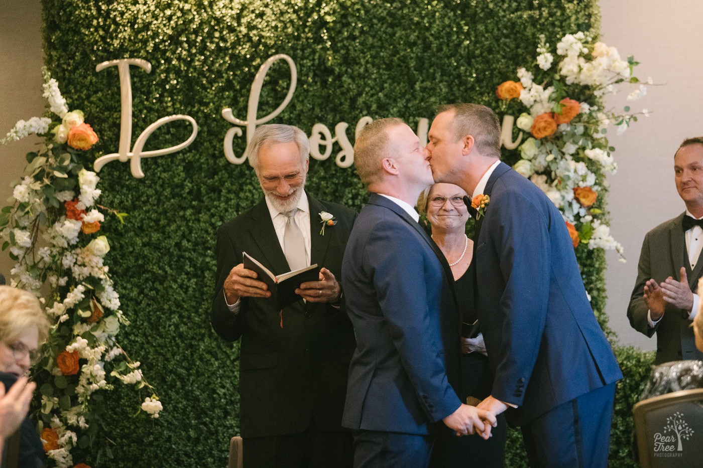 Grooms kissing after getting married inside Renaissance Concourse Atlanta Airport Hotel.