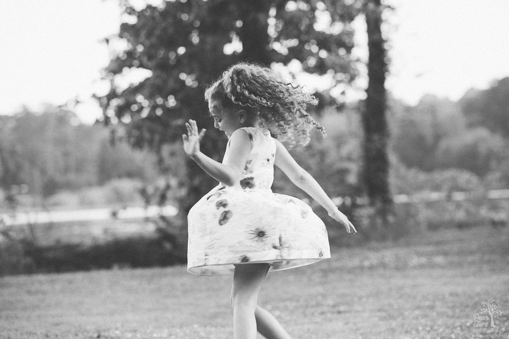 Little girl twirling and making her dress fly out.