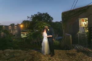 Inter-racial newlywed couple photographed by Atlant wedding photographer while standing in front of Urban Tree Cidery.