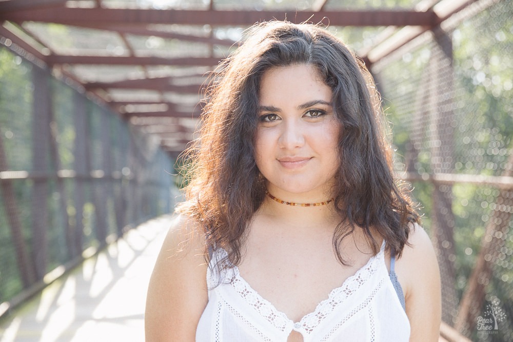 Beautiful teenage girl looking into the camera under a bridge and smiling.