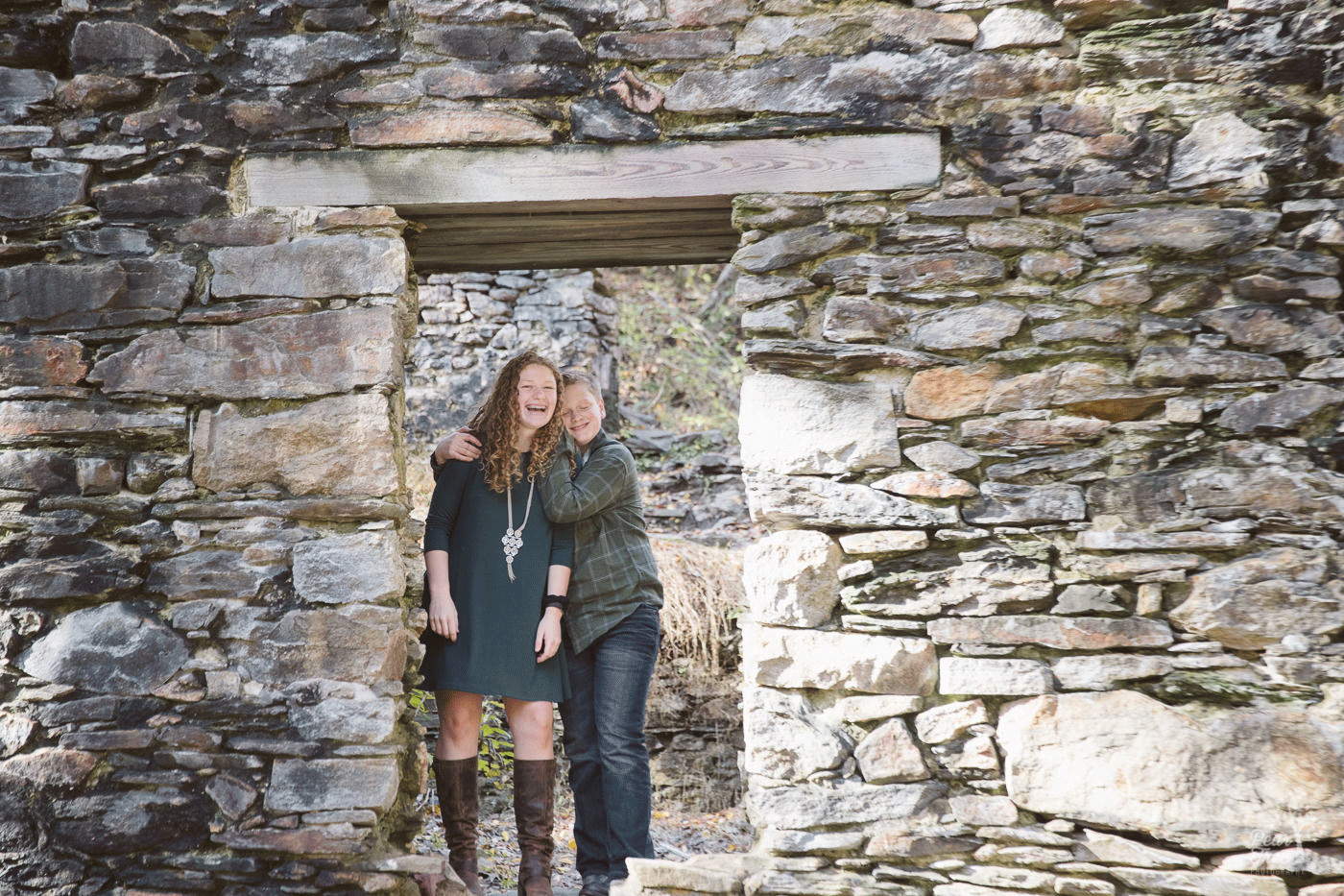 Teenage brother and sister being silly and standing together in Paper Mill ruins doorway at Sope Creek in East Cobb.
