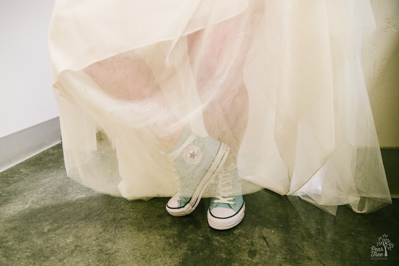 Turquoise high top Converse wearing bride.