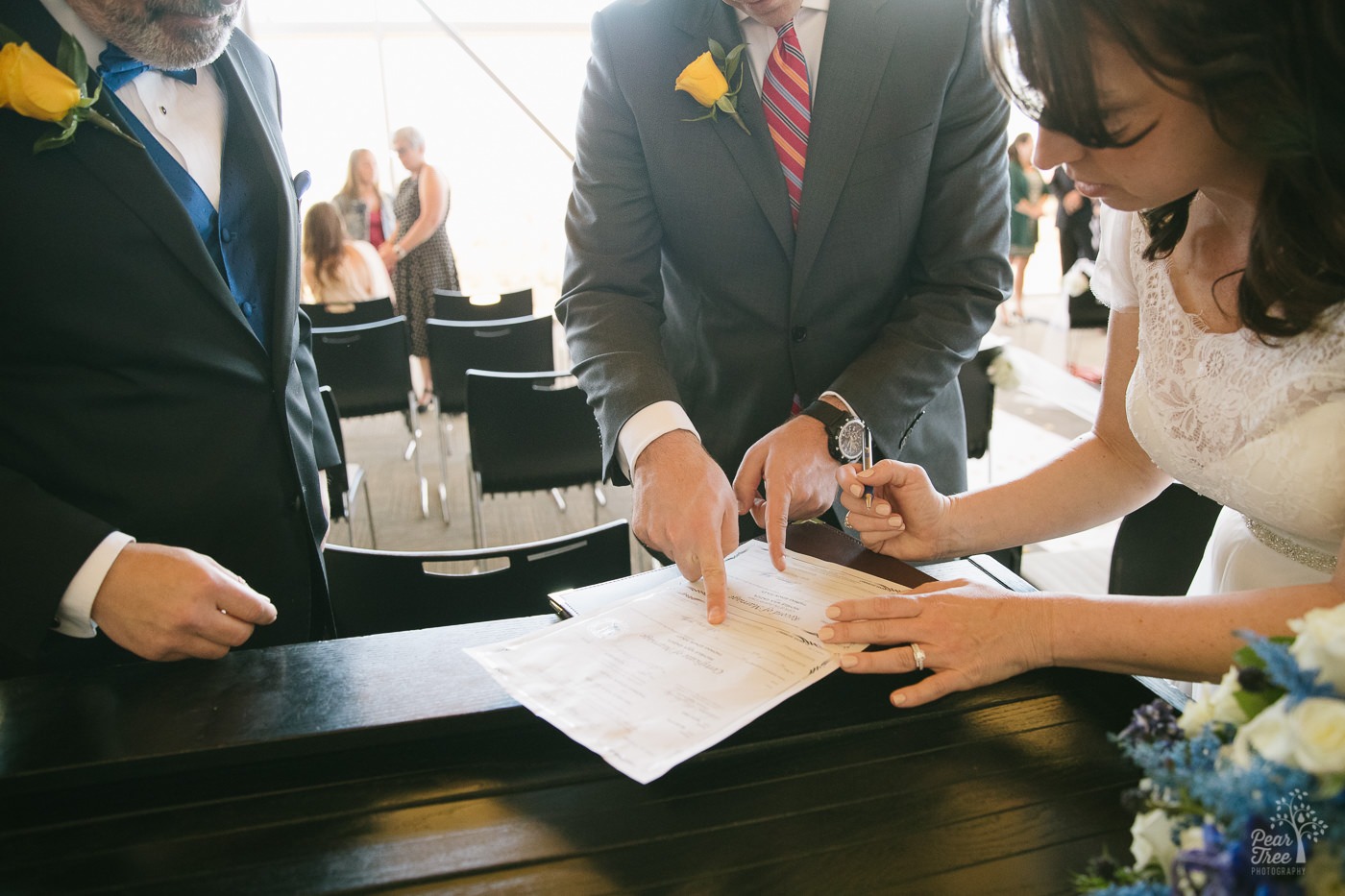 Bride and groom figuring out where to sign the marriage license.