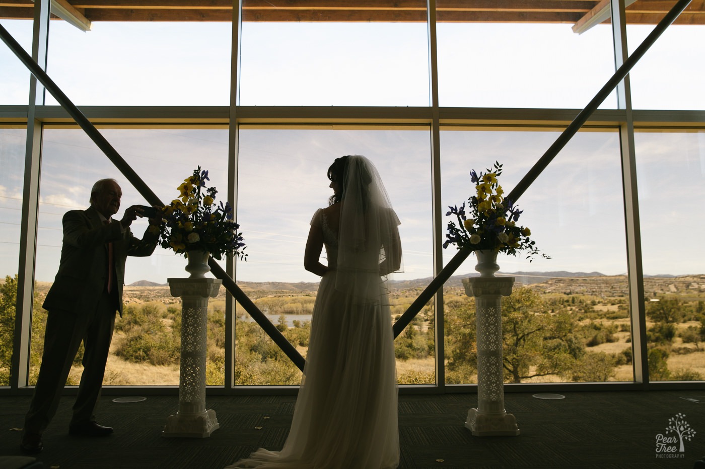 Father-in-law photographing the bride inside Embry Riddle Chapel in Arizona.