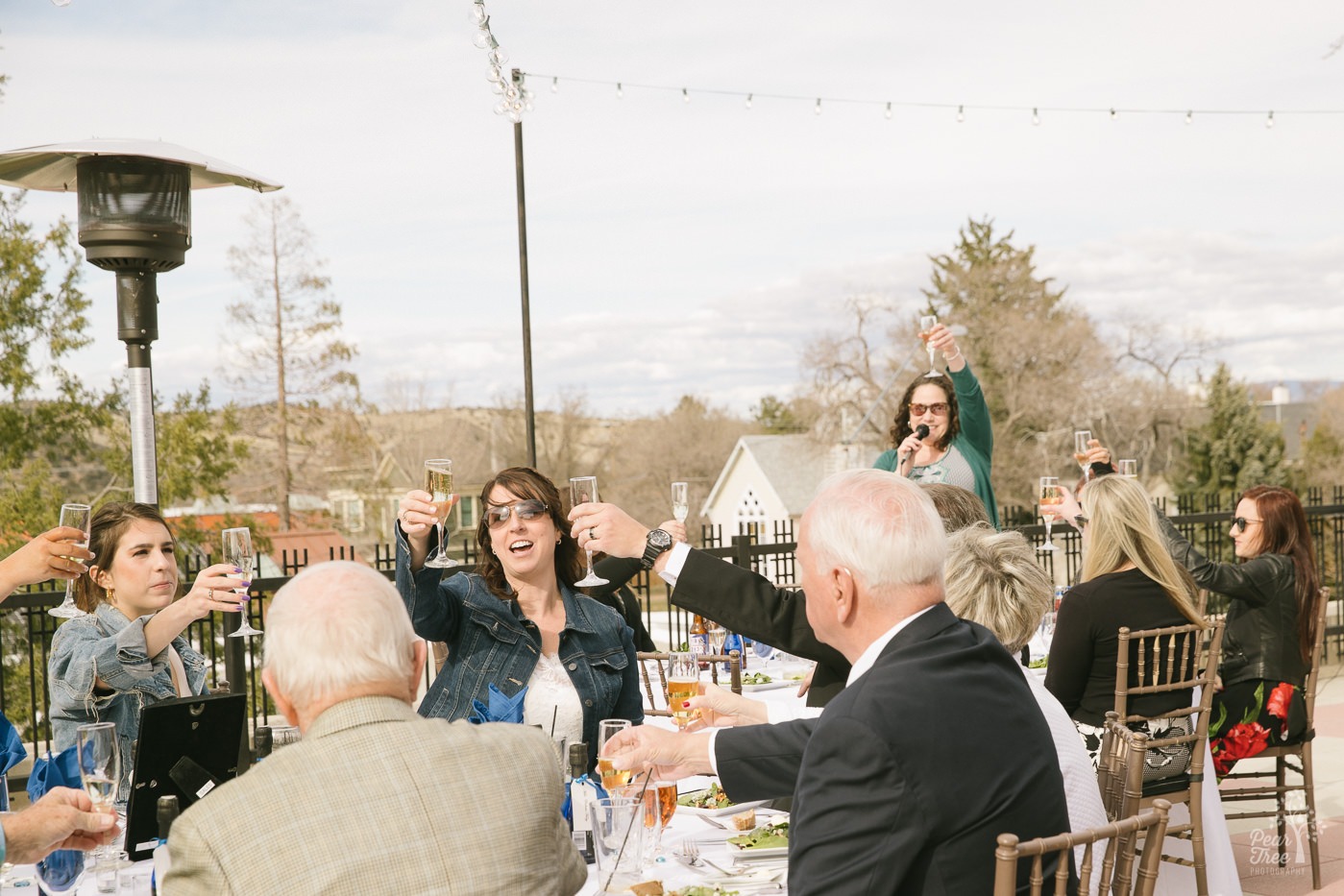 Wedding day toast with champagne glasses raised.