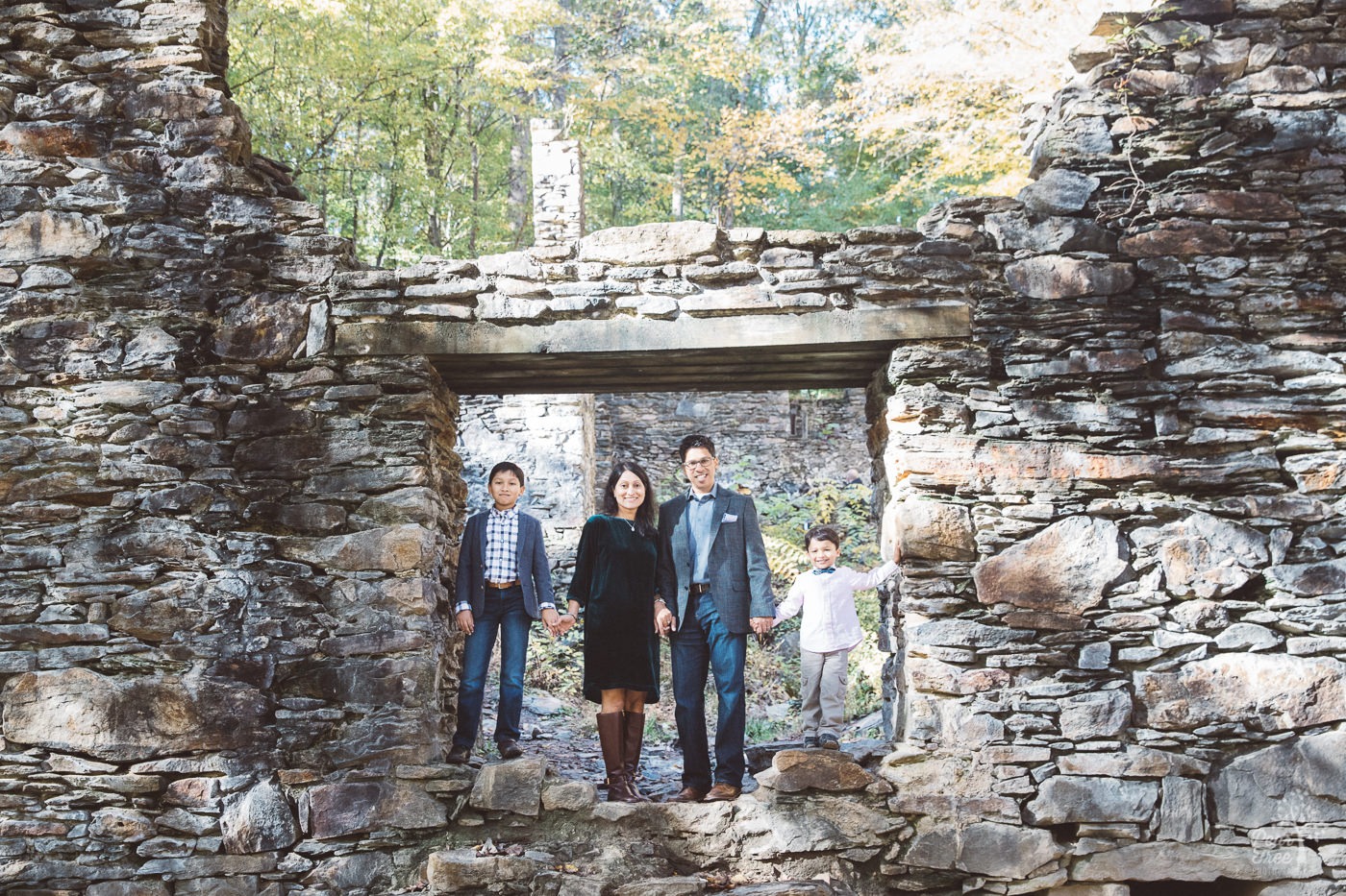 Family of four standing inside Sope Creek Mill Ruins on a fall morning.