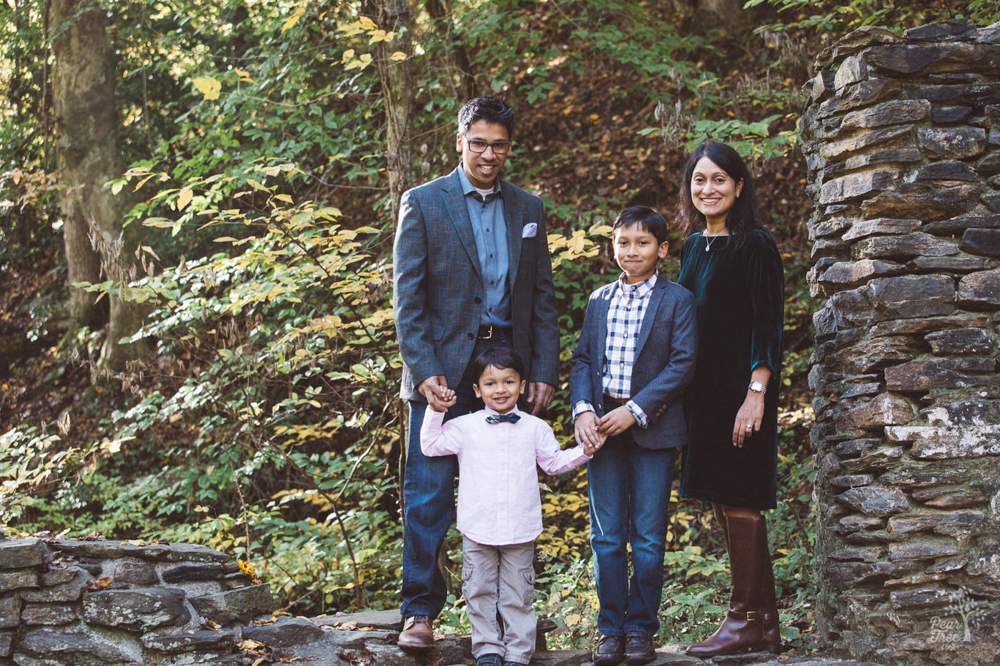 Family of four standing together in Sope Creek Mill Ruins.