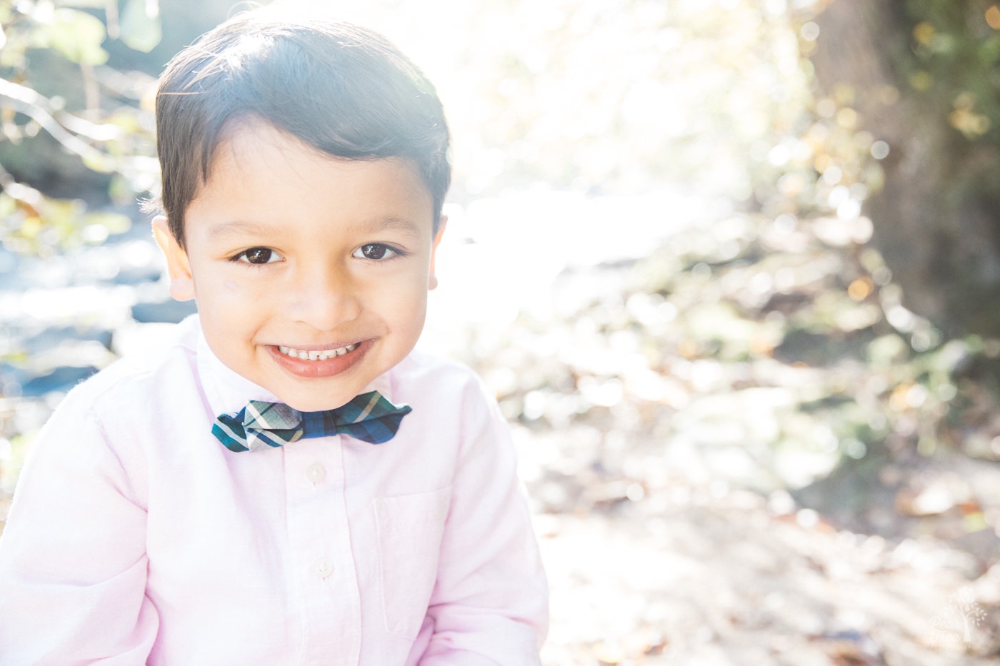 Little boy in bow tie and pink shirt smiling sweetly at Sope Creek.