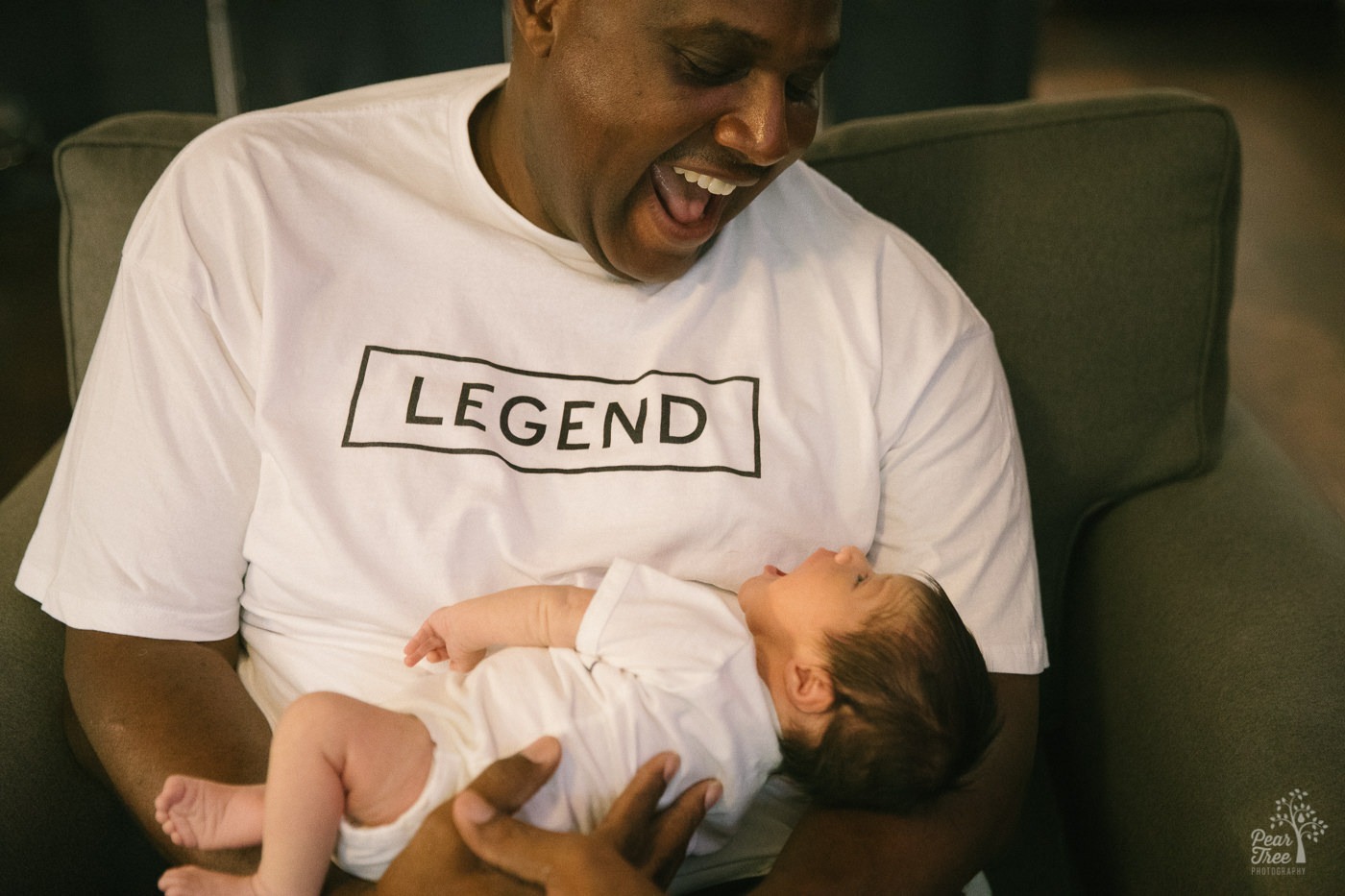 Smiling Dad holding his five day old son.