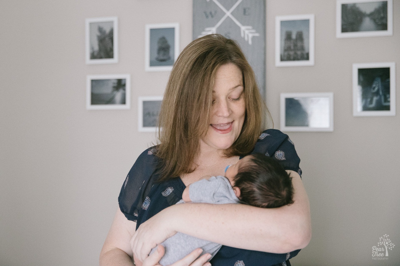 Mom holding her newborn baby boy and singing to him.