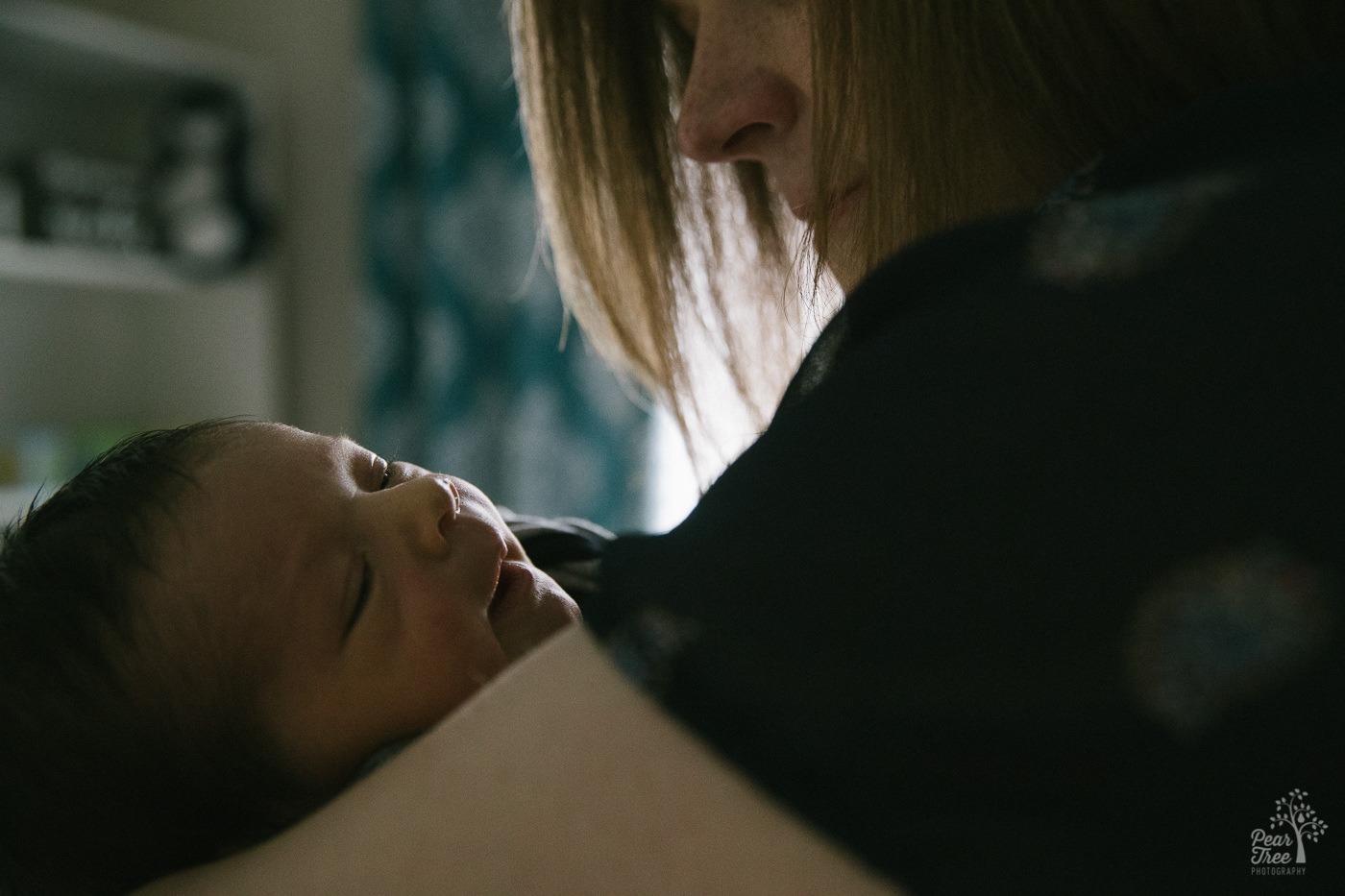 Mom holding her smiling newborn baby boy.