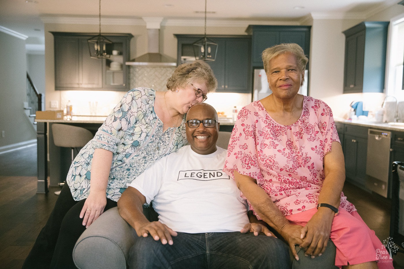 Both grandmas sitting next to their son and son-in-law during a lifestyle legacy newborn session