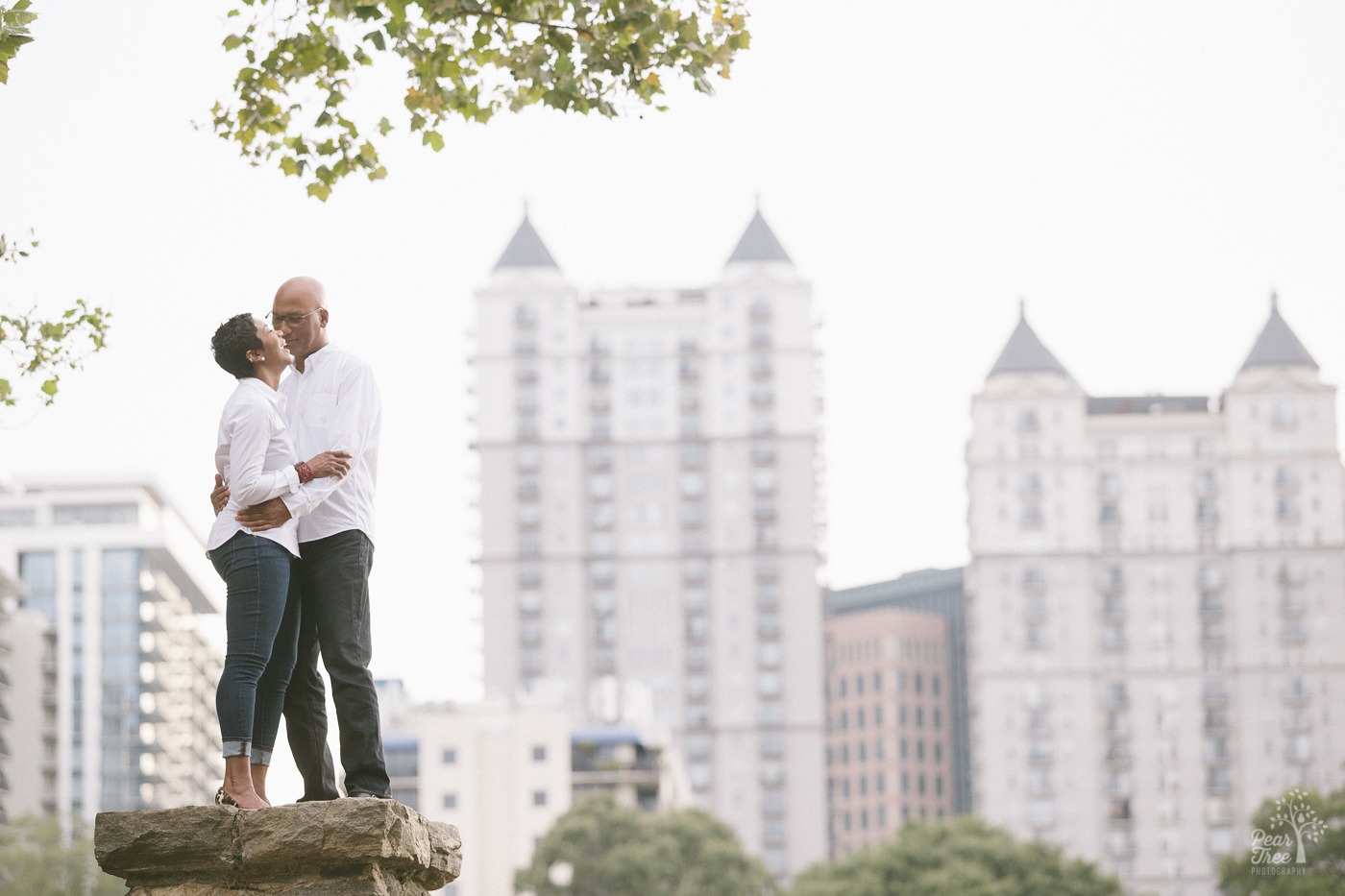 Engagement session with an engaged couple standing in midtown Atlanta skyline inside Piedmont Park