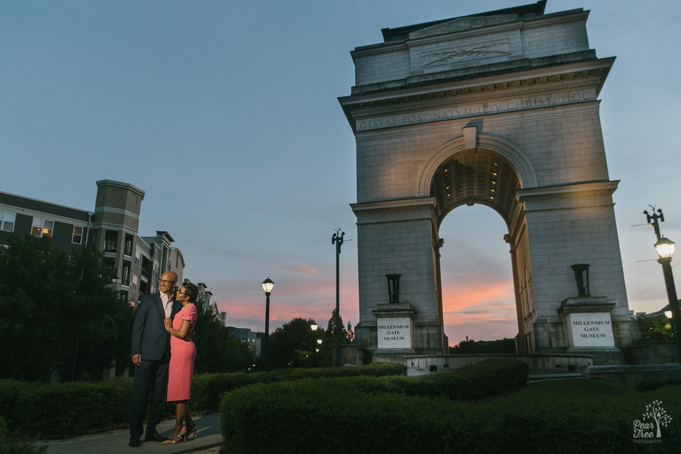Engagement session with a couple standing in front of Millenium Gate in midtown Atlanta at sunset.
