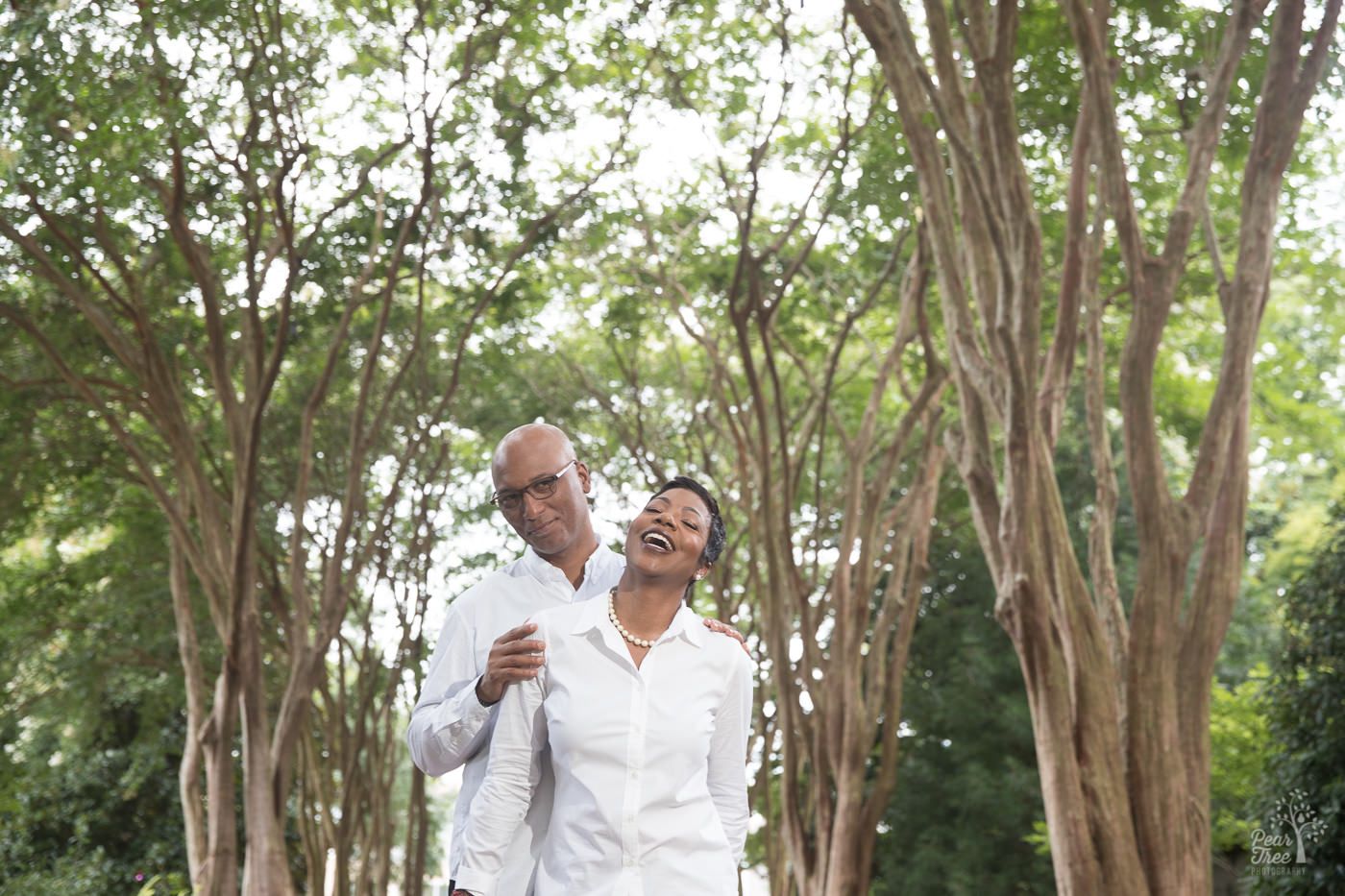 Smiling and laughing couple in middle of Atlanta Botanical Garden crepe myrtles walkway