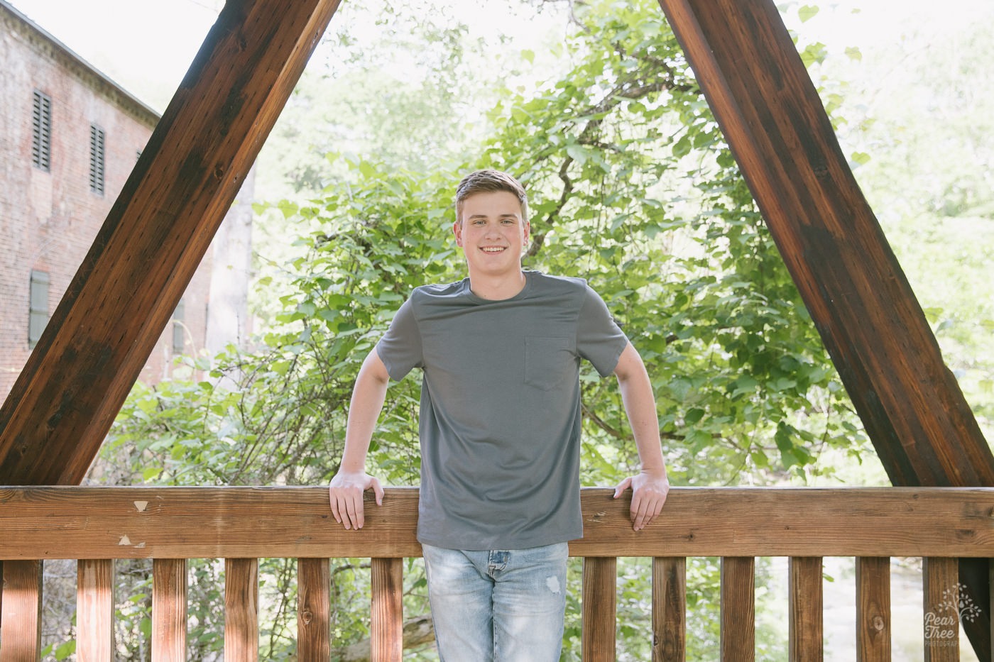 A teenage boy's Woodstock high school senior session inside covered bridge at Roswell Mill.