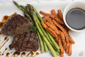 Delicious steak, asparagus, and sweet potato fries plated by Divine Taste of Heaven