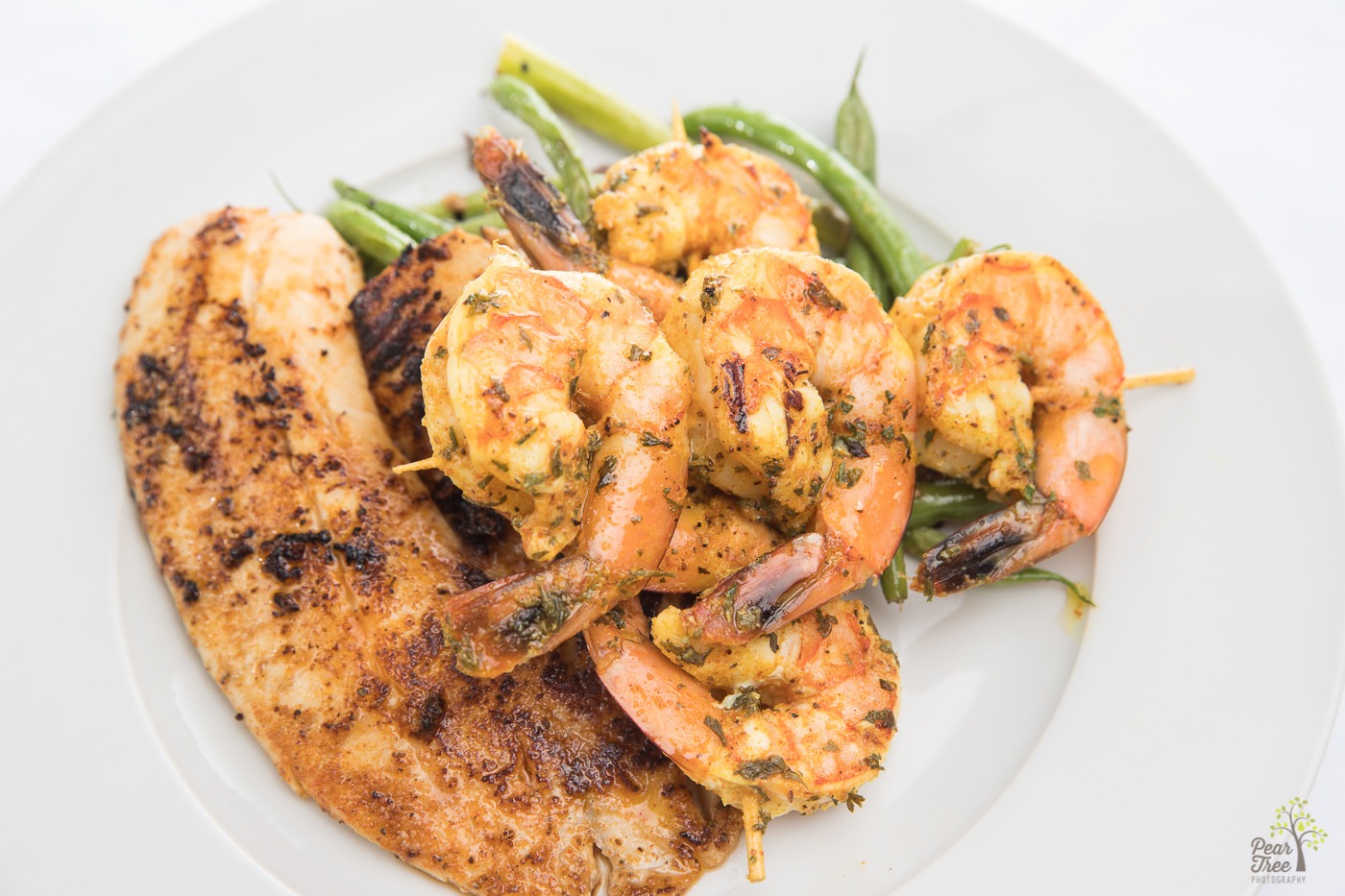 Cajun tilapia and shrimp on sauteed garlic green beans prepared by Divine Taste of Heaven.