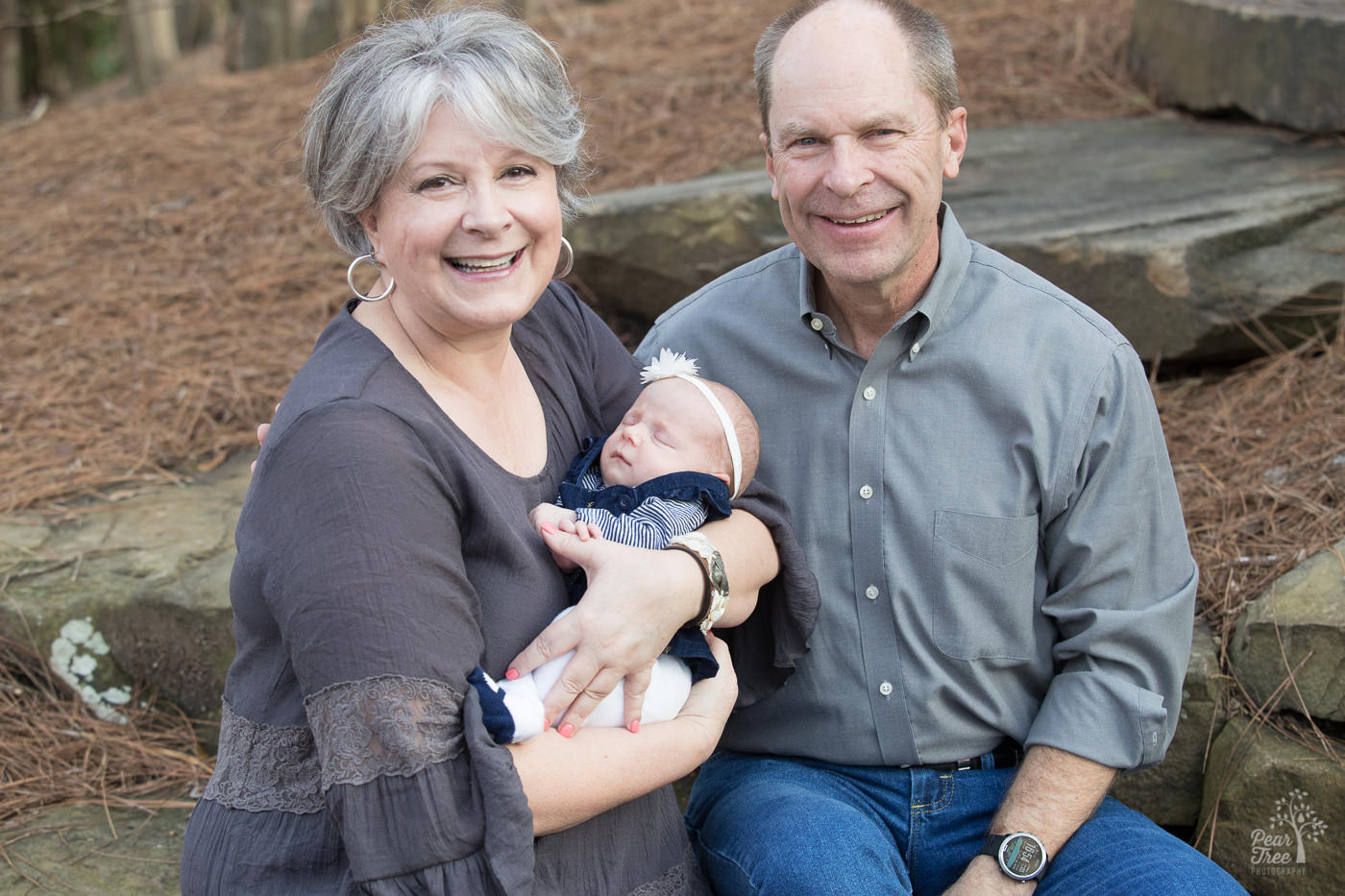 Happy grandparents holding their sweet newborn granddaughter.