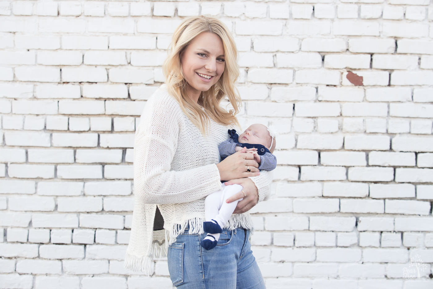 Happy blonde aunt holding her newborn niece in downtown Woodstock.