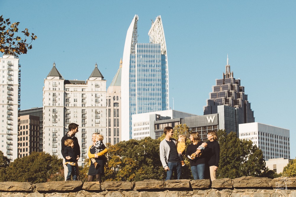 Three generations, two families, and one grandma standing in front of Atlanta skyline.