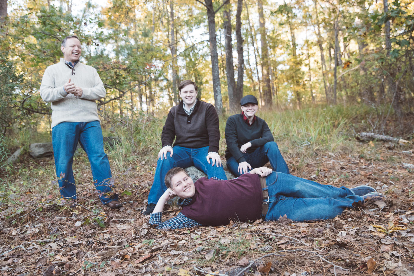 Dad with three teenage sons being silly in Stone Mountain woods.