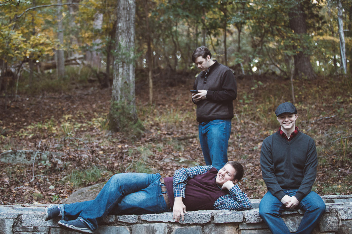 Three teenage brothers goofing off in the middle of a family photography session in Stone Mountain.