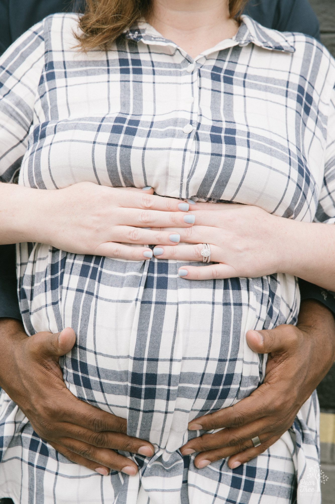 Pregnant belly with mom's hands on top and dad's hands holding underneath.