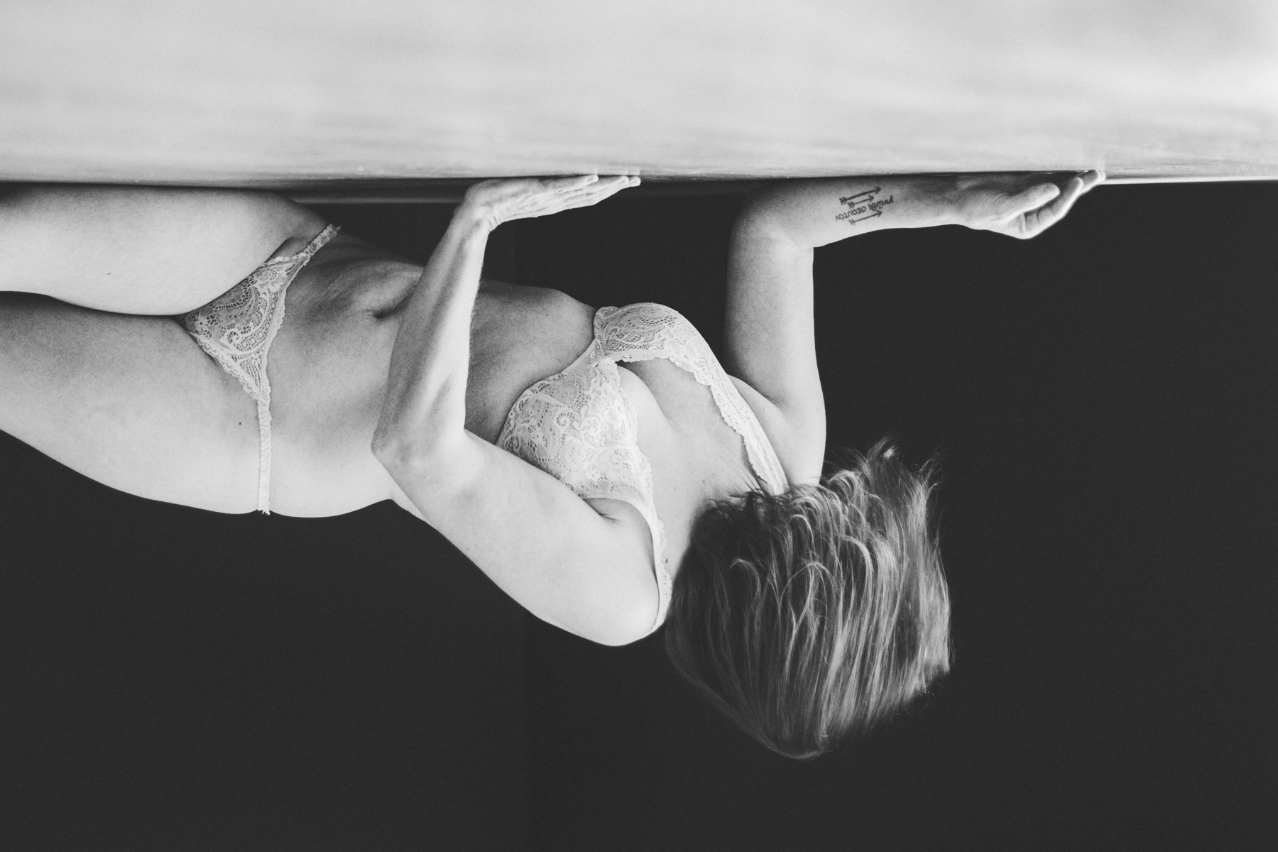 Woman in lingerie laying on floor and turned upside down
