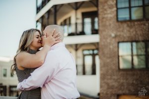 Gorgeous blond pulling her fiance close and holding his head while she goes in for a kiss at Avalon during their engagement session
