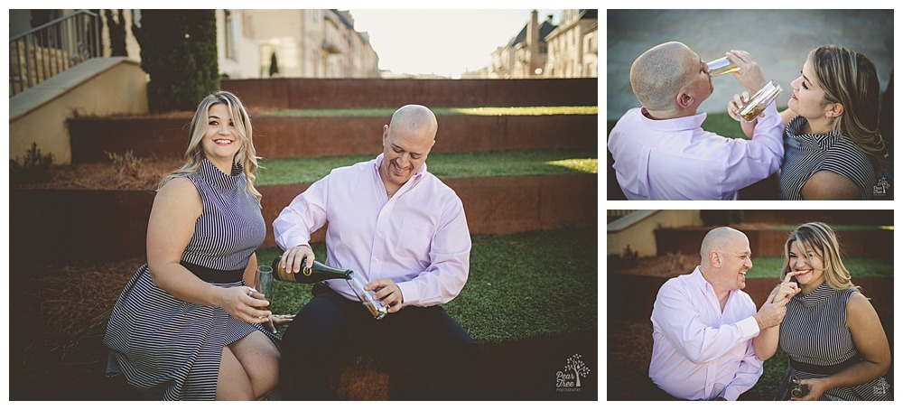 Engaged couple pouring and drinking champagne while sitting on terrace steps in Avalon.