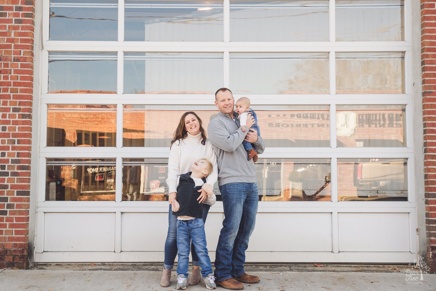 Sweet family of four posing in front of Canton firestation door