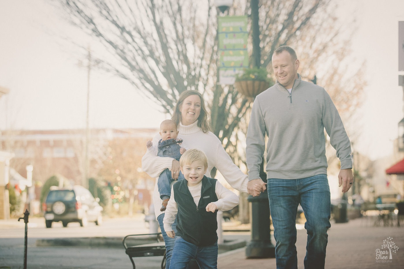 Happy family of four walking through downtown Canton at Christmastime