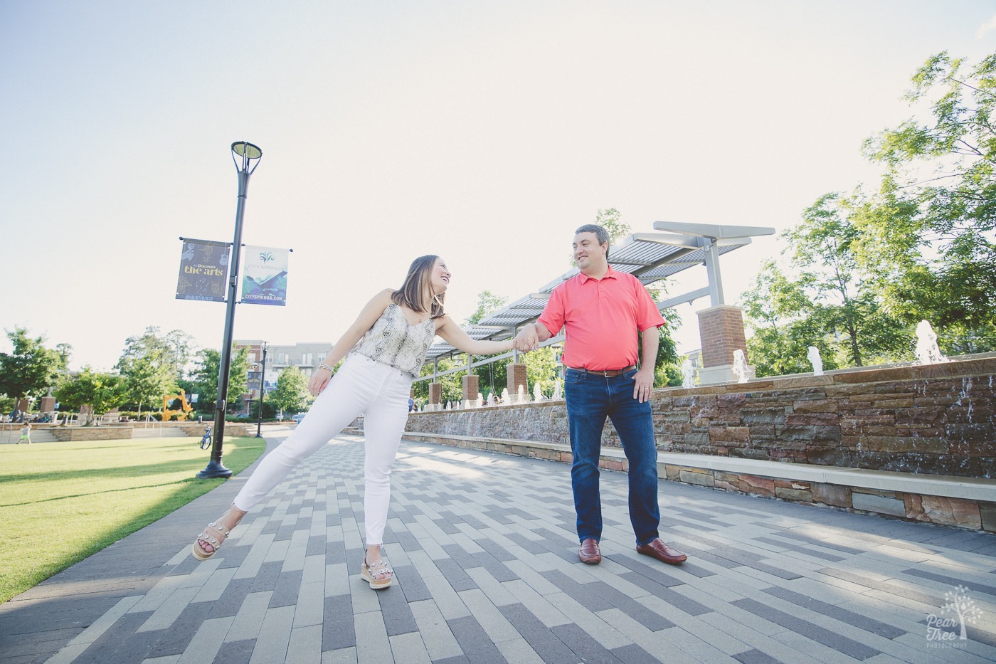 Fun couple playing at City Springs on brick path