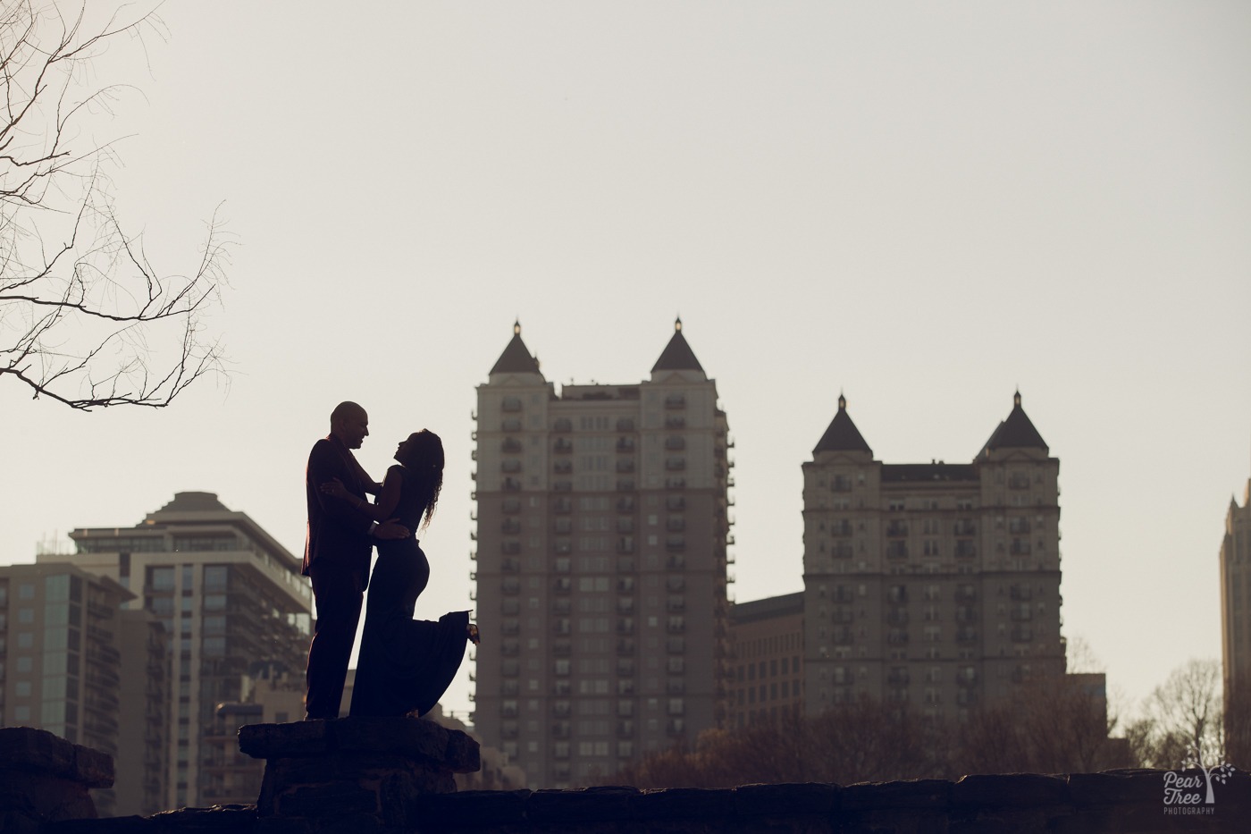 Silhouette view of a couple in the Atlanta skyline wearing formal attire for anniversary photos