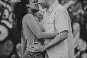 African American couple embracing and about to kiss in front of grafitti wall