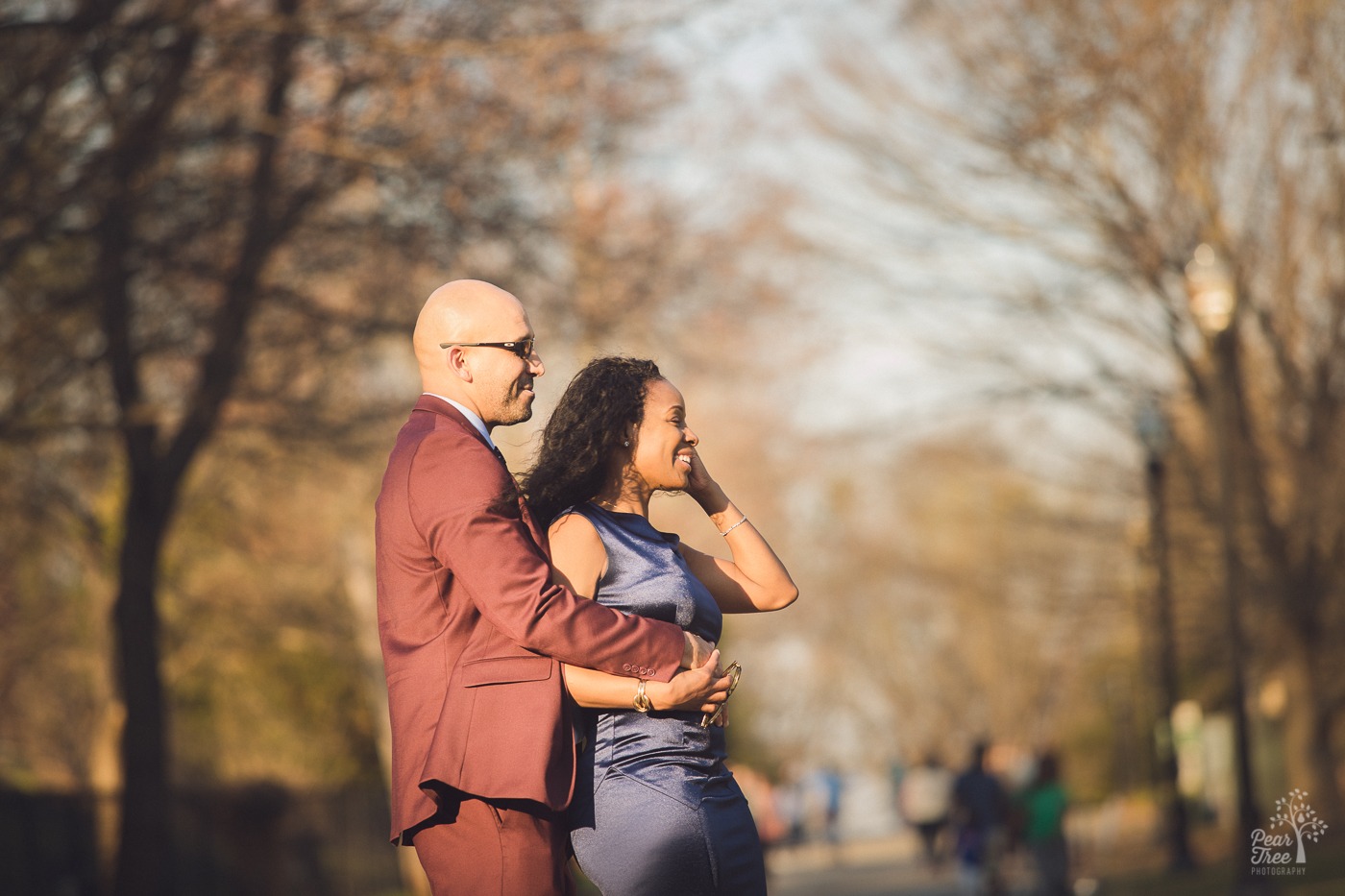 African American couple dancing and smiling in Piedmont Park with the man wearing sunglasses and woman brushing her hair out of her face