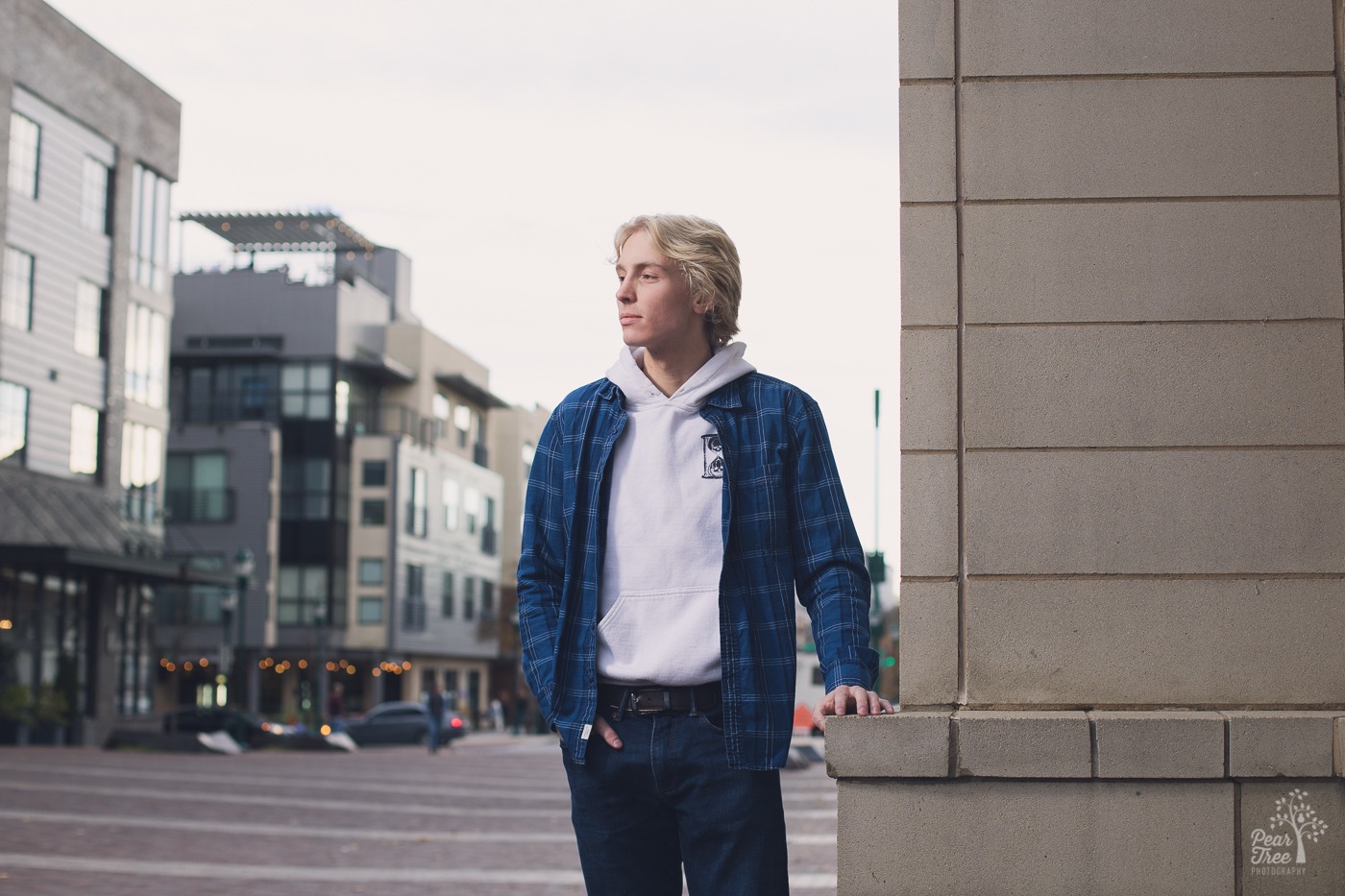 High school senior boy standing at the corner of a building in downtown Chattanooga