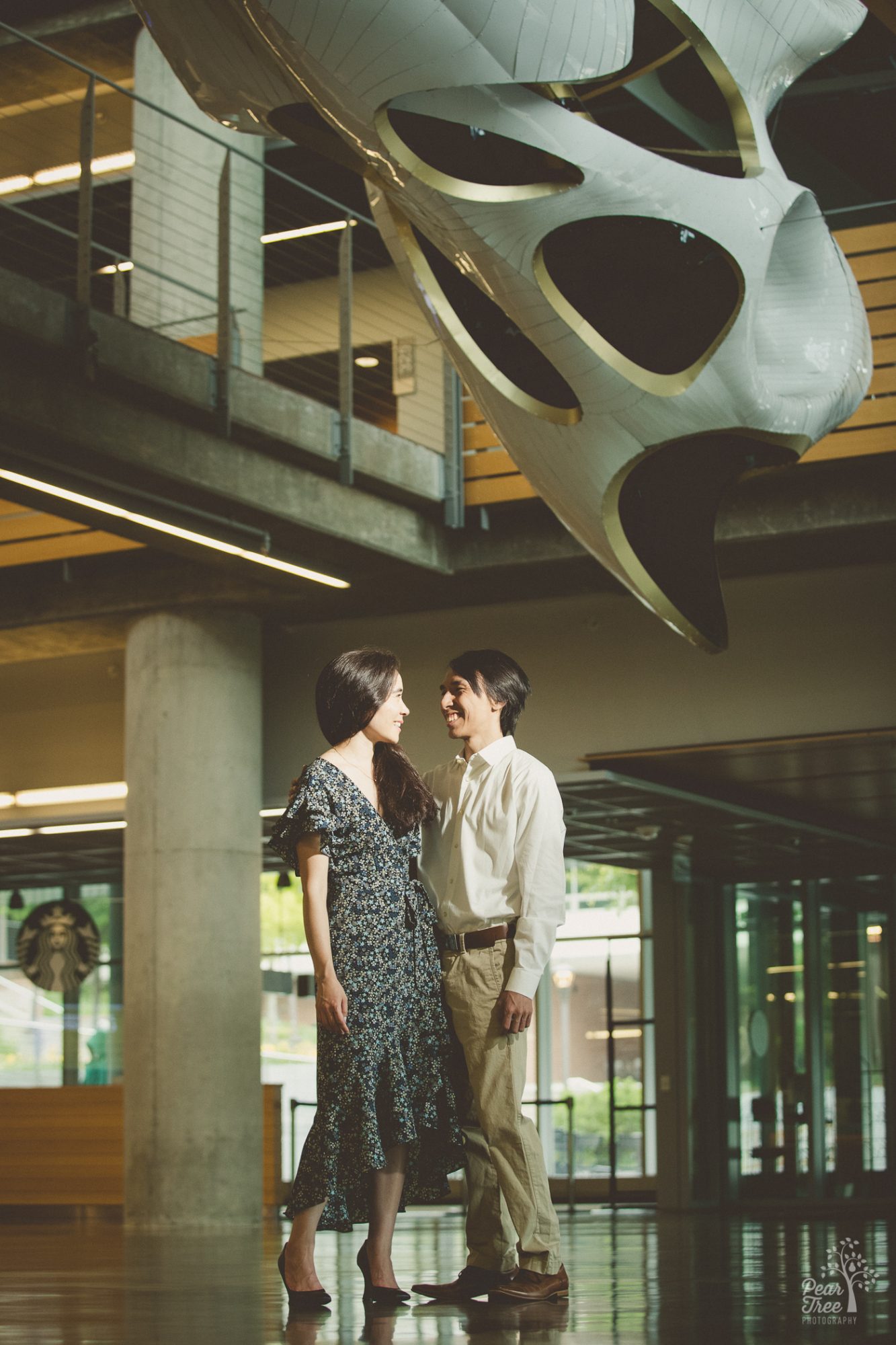 Two architects standing under the sculpture they helped design and build at Georgia Tech during their engagement photography session.
